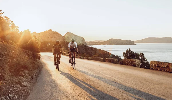 Due ciclisti professionisti di sesso maschile in sella alle loro biciclette da corsa al mattino insieme — Foto Stock