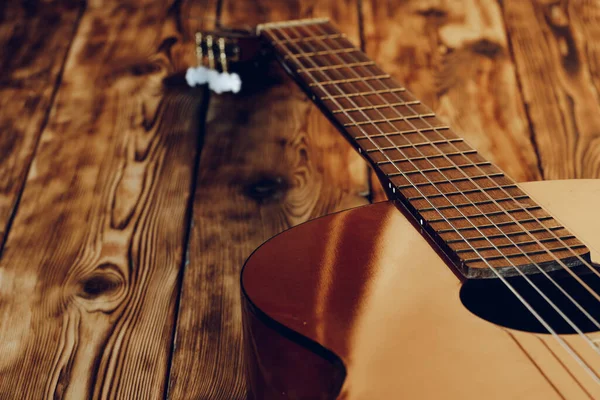 Wooden acoustic guitar body and fingerboard close up