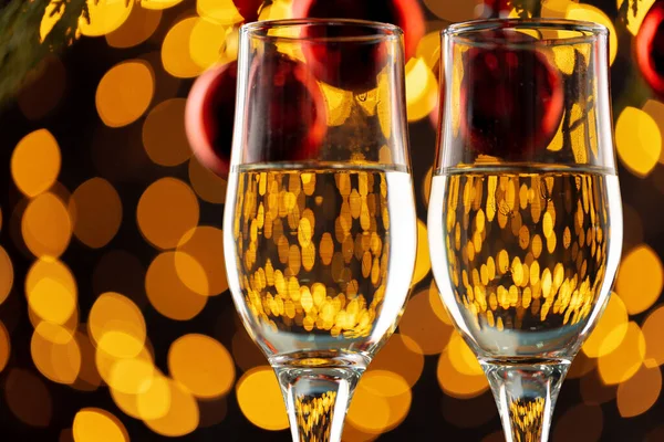 Två glas champagne och julgranskulor på bokeh ljus bakgrund — Stockfoto