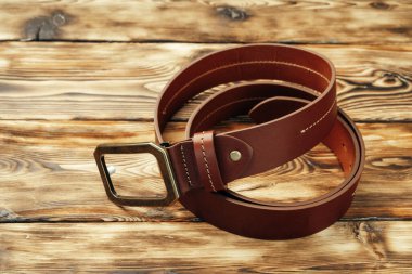 Kahverengi ahşap arka planda şık erkek kemeri.