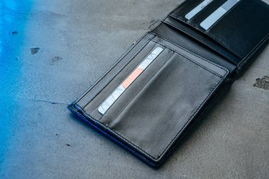 Gri beton arka planda siyah deri cüzdan