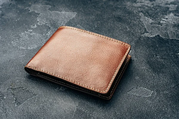 Nowy brązowy skórzany portfel na ciemnym tle — Zdjęcie stockowe
