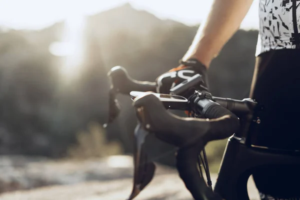 자전거 손잡이에 장갑을 끼고 자전거를 타고 있는 전문 자전거 선수의 손 — 스톡 사진