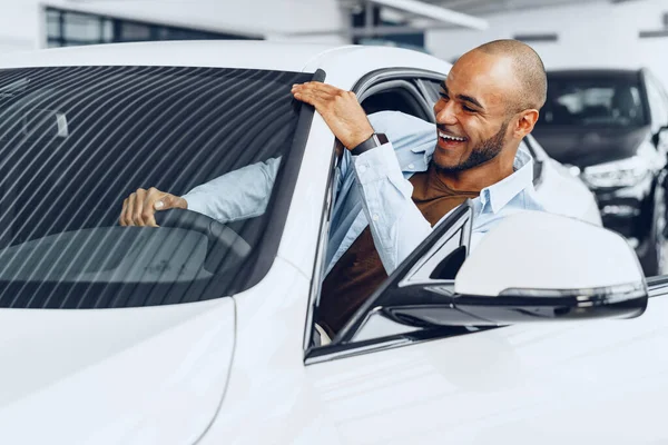 Portret przystojnego, szczęśliwego Afroamerykanina siedzącego w nowo kupionym samochodzie — Zdjęcie stockowe