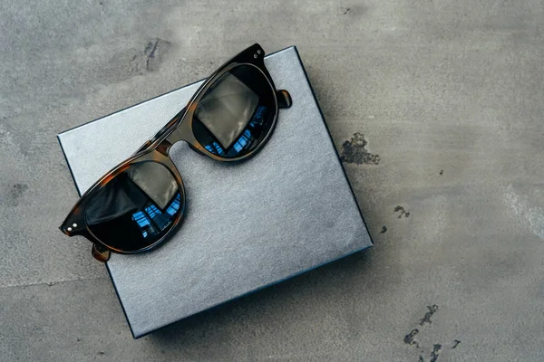 Dark male sunglasses on grey concrete surface — Stock Photo, Image