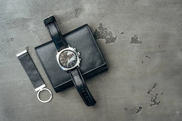 Ανδρικό ρολόι και δερμάτινο πορτοφόλι σε σκούρο γκρι επιφάνεια — Φωτογραφία Αρχείου