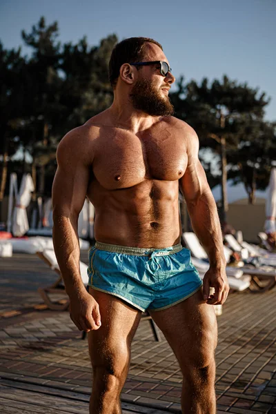 Muskulöse Mann Bodybuilder Bräune in einem Beach-Club — Stockfoto