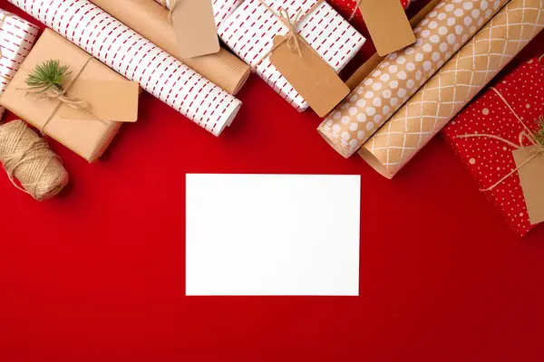 Concepto de preparaciones navideñas con papel de regalo, cajas de regalo sobre fondo rojo —  Fotos de Stock