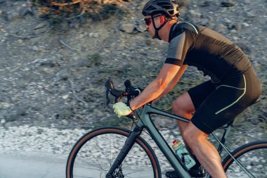 Gündoğumunda dağ yolunda profesyonel bisikletçi.