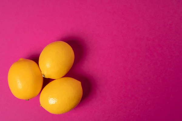 Limones maduros sobre fondo de papel rosa brillante —  Fotos de Stock