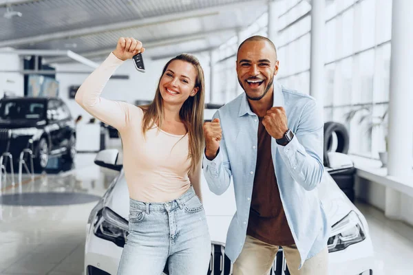 Feliz casal animado comprando um carro novo e mostrando chaves — Fotografia de Stock