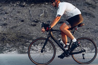 Gündoğumunda dağ yolunda profesyonel bisikletçi.