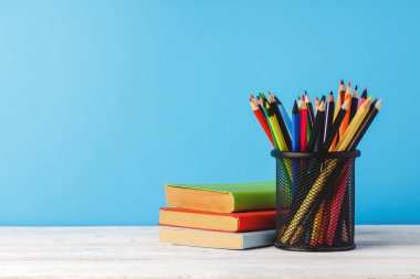 Renkli kalemler ve bir yığın kitap.