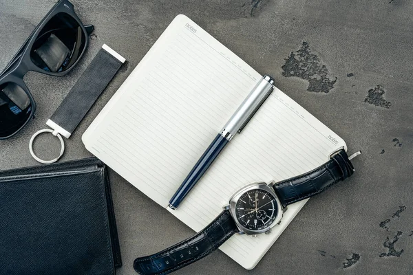 Businessmans accessoires waaronder notitieblok, horloge en portemonnee op donkergrijze achtergrond — Stockfoto