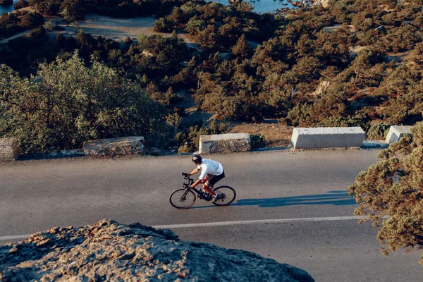 Ciclista in sella alla sua bicicletta sulla strada costiera — Foto Stock