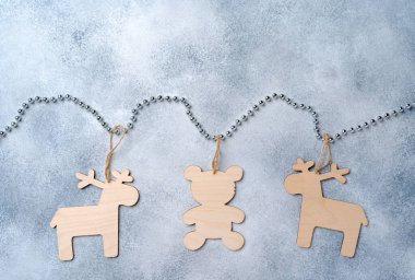Gri arka planda gümüş boncuklarda tahta Noel oyuncakları