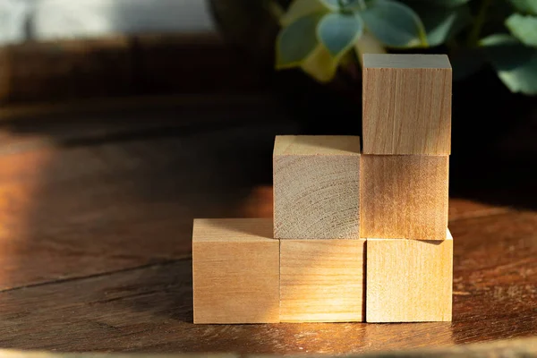 Blocos quadrados de madeira agrupados em mesa de madeira escura — Fotografia de Stock
