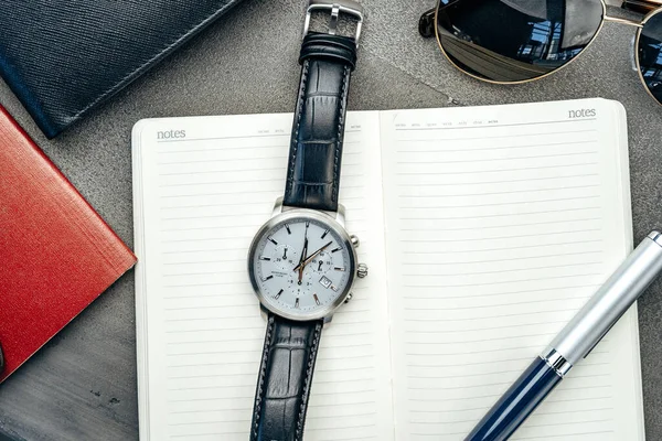 Mannelijke horloge en notitieblok op donkergrijze tafel — Stockfoto