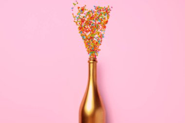 Konfetili şampanya şişesi düz bir manzarada duruyordu.