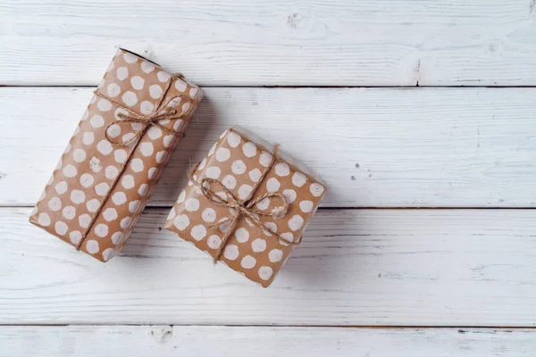 Regalos de Navidad envueltos en tablero de madera blanco, vista superior —  Fotos de Stock