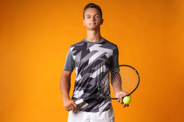 Retrato de um jovem jogador de tênis em fundo laranja — Fotografia de Stock