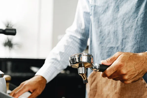 Tanımlanamayan adam kahve makinesinde kahve hazırlıyor.
