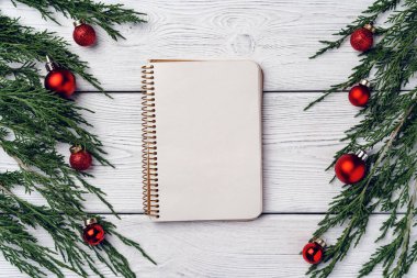 Kozalaklı dalları ve Noel süslemeleri olan beyaz ahşap zemin