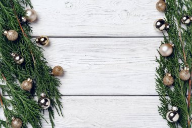 Kozalaklı dalları ve Noel süslemeleri olan beyaz ahşap zemin