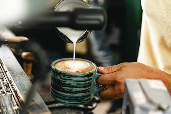 Woman coffee shop worker preparing coffee on professional coffee machine