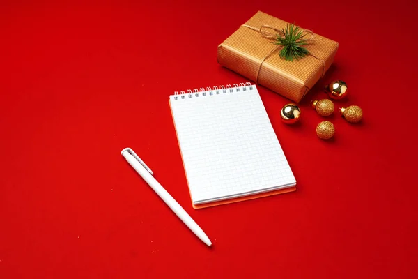 紙のブランクシートと赤の背景にクリスマスのお祝いのためにプレゼントを包んだ — ストック写真