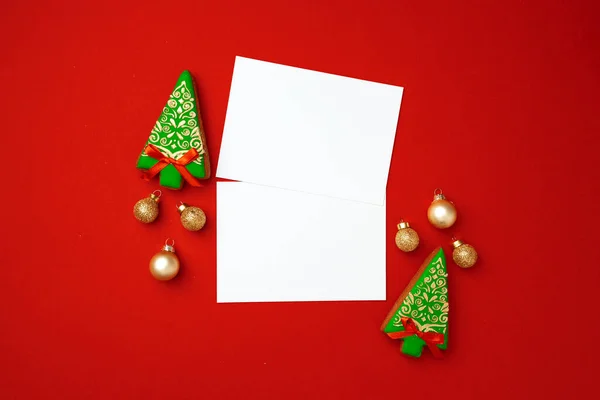 Prázdný list papíru s perníkovými sušenkami na červeném pozadí — Stock fotografie