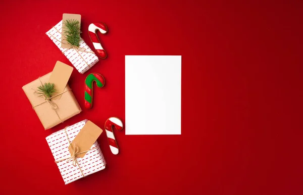 Vánoční dárek a perník sušenky na červeném pozadí — Stock fotografie
