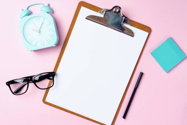 Pembe üzerinde boş kağıt ve alarm saati olan pano