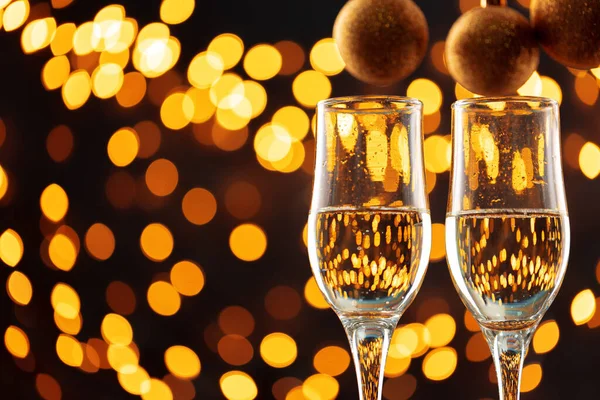 Twee glazen champagne en kerstballen op bokeh lichten achtergrond — Stockfoto