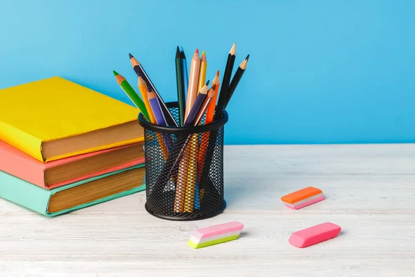 Coupe de crayons de couleur et pile de livres — Photo