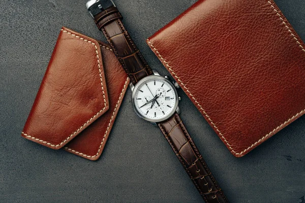 Mannelijke horloge en lederen portemonnee op donkergrijs oppervlak — Stockfoto