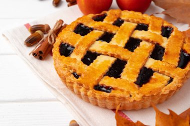 Kuru yapraklar ve tarçın çubuklarıyla süslenmiş beyaz tahta üzerinde sonbahar teşekkür pastası.