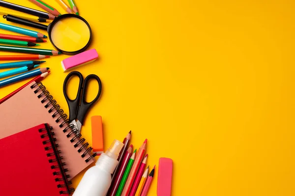 Bloco de notas e lápis de cor na vista superior do espaço de trabalho — Fotografia de Stock