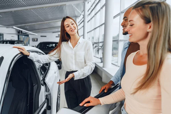 Autohändlerin erklärt Käufern Merkmale ihres neuen Autos — Stockfoto