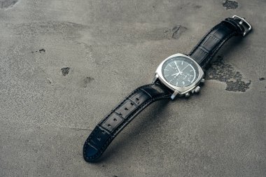 Koyu beton yüzeyde erkek mekanik saati