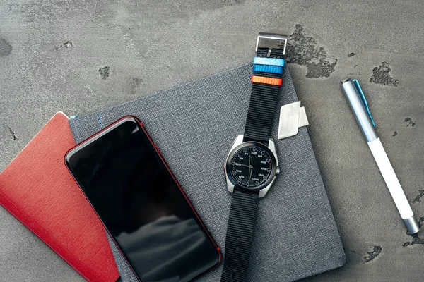 Heren accessoires zoals smartphone en horloge op donkergrijze tafel — Stockfoto