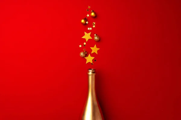 Botella de champán con confeti espumoso sobre fondo rojo plano laico —  Fotos de Stock