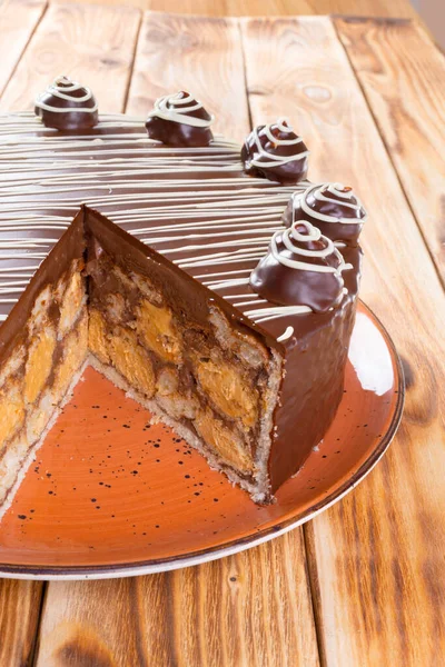 Skär chokladtårta på tallrik på träbord — Stockfoto