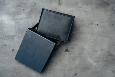 Gri beton arka planda siyah deri cüzdan