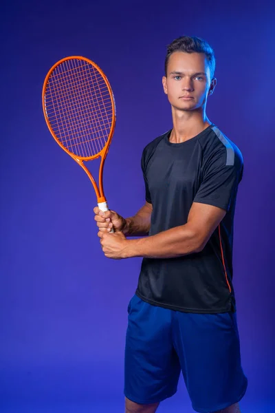 Jovem jogador de tênis branco posando com raquete de tênis contra fundo roxo — Fotografia de Stock
