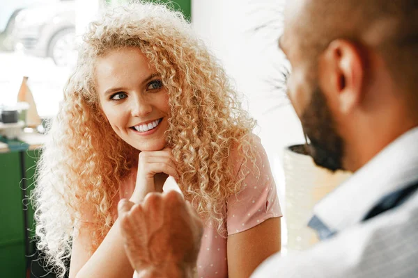 Leende blond kvinna som pratar med en servitör på ett kafé vid disken — Stockfoto