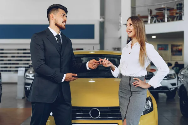 Młoda atrakcyjna kobieta kupuje nowy samochód w salonie samochodowym — Zdjęcie stockowe