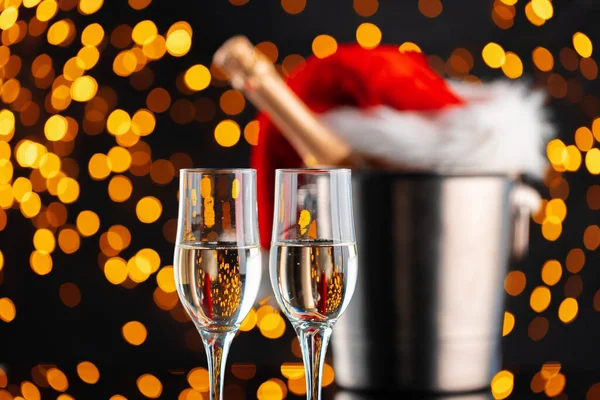 Champagne en Santa Claus hoed op wazig bloemenslinger achtergrond — Stockfoto