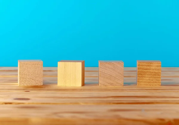 Stacked wooden blocks on wooden desk against blue background
