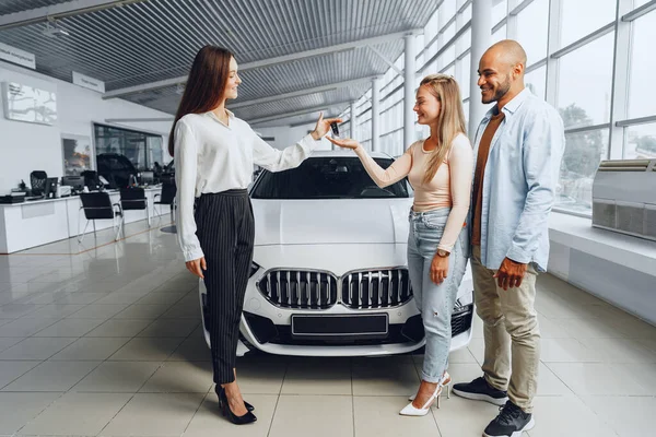 Sprzedawczyni samochodów w salonie samochodowym rozmawiająca z klientami — Zdjęcie stockowe